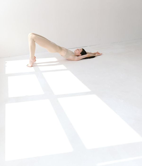 Woman performing a serene yoga pose in a bright, calm studio.